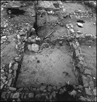 Room 8 in foreground, facing west. Note overturned metate and slab in corner hearth. (BW-YJ-JC-008)